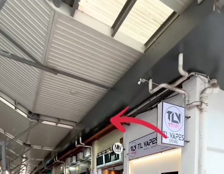 Laluan arked berbumbung di bahagian luar Metrocity Square, anak panah merah menunjuk ke arah kedai